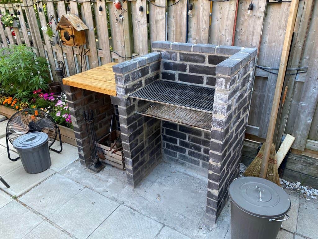 A hand constructed built barbeque in a backyard